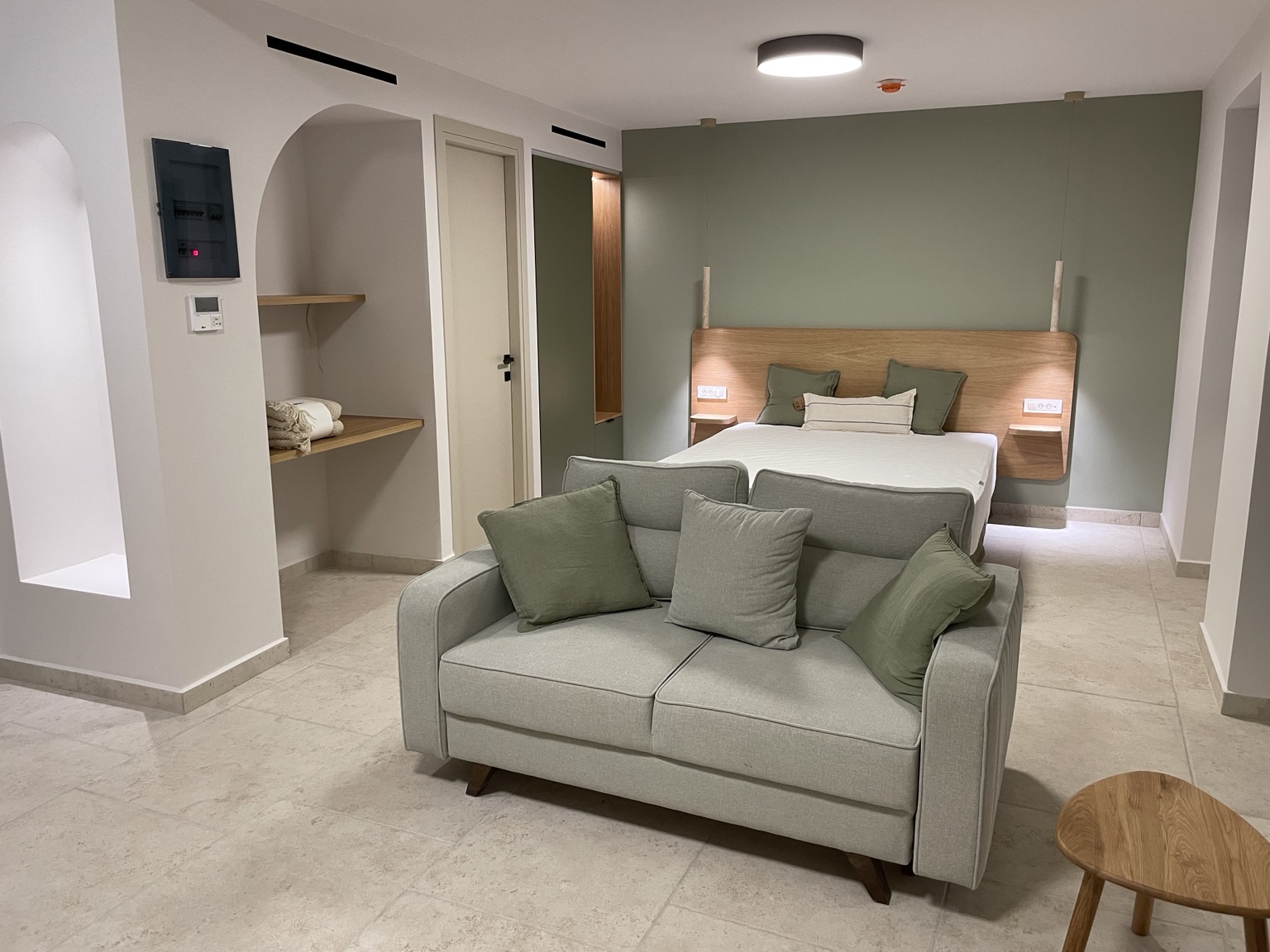Olive apartment with sofa, bed and olive green feature wall