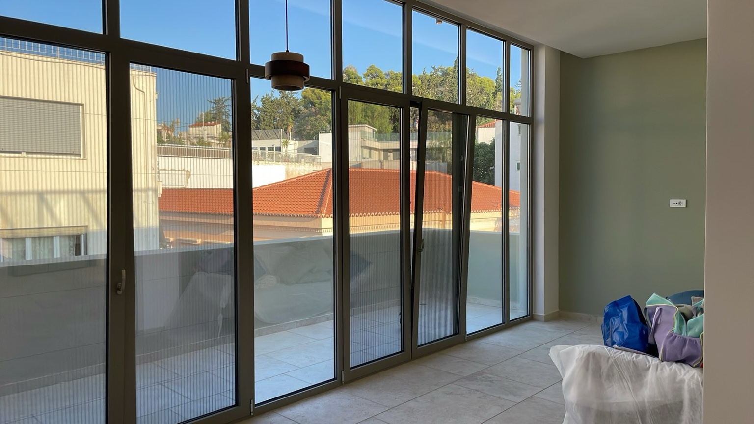 Sunlit Olive apartment with full-height windows and Athens view
